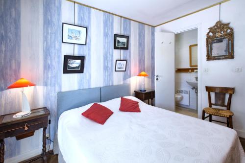a bedroom with a bed with two red pillows on it at Villa Surprise in Arcachon