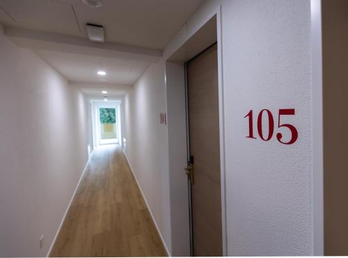 an empty hallway with a number on the door at Hotel MeiSTAY - Self-Check-in in Meisterschwanden