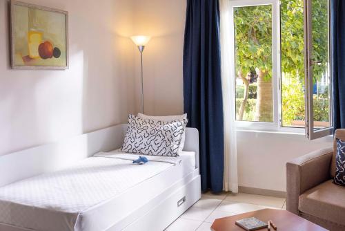 a living room with a couch and a window at TUI BLUE Pascha Bay in Konaklı
