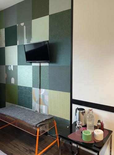 a room with a table and a tv on a wall at Les Cépages in Le Mesnil-sur-Oger