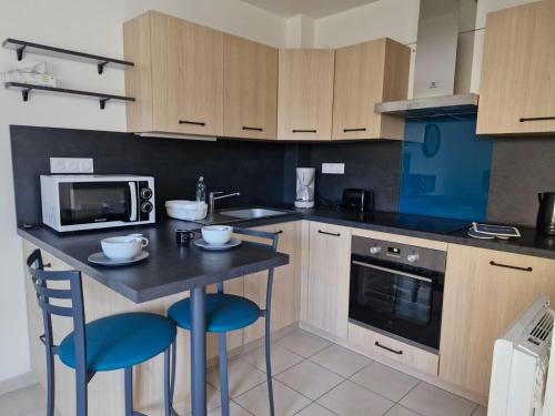 a kitchen with a table and two chairs and a microwave at les tilleuls in Saint-Planchers