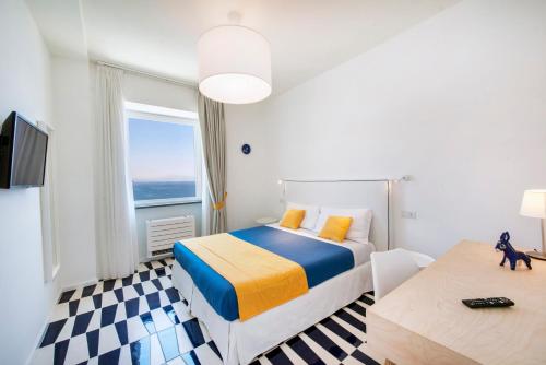 a hotel room with a bed and a window at Le Tre Sirene Rooms in Atrani