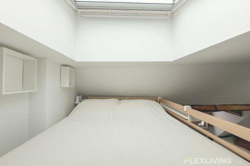 un grand lit dans une chambre avec une fenêtre dans l'établissement Flexliving - studio - Varennes, à Paris