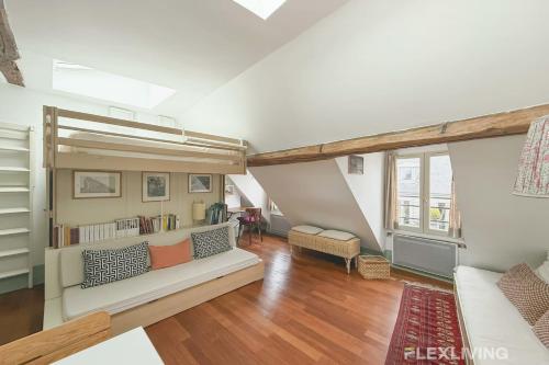 un salon avec un canapé et une grande fenêtre dans l'établissement Flexliving - studio - Varennes, à Paris