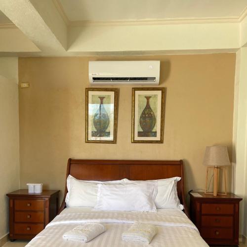 a bedroom with a bed with two pictures on the wall at Gold View Beachfront Resort in Timbaon