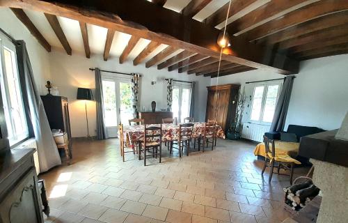 ein Wohnzimmer mit einem Tisch und Stühlen in der Unterkunft Villa coco 9 personnes jardin proche Beauval in La Vernelle