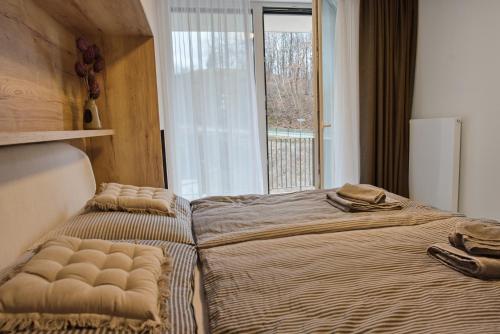 two beds in a room with a window at Bohemian Glow of Krumlov in Český Krumlov