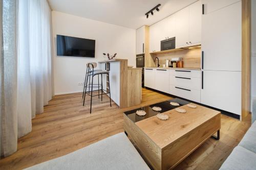 a kitchen with white cabinets and a coffee table at Bohemian Glow of Krumlov in Český Krumlov