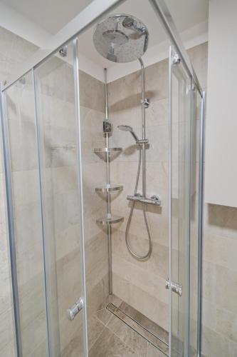a shower with a glass enclosure in a bathroom at Bohemian Glow of Krumlov in Český Krumlov