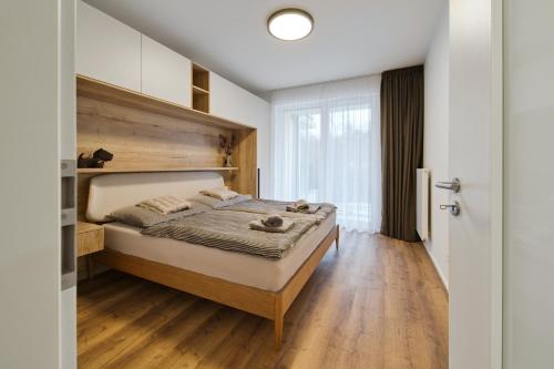 a bedroom with a large bed with a wooden headboard at Bohemian Glow of Krumlov in Český Krumlov