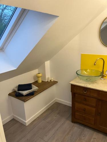 a bathroom with a sink and a glass bowl on a counter at Le Dervillé in Roz-sur-Couesnon