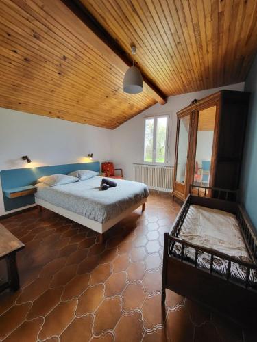 - une chambre avec un grand lit et un plafond en bois dans l'établissement Chez Léontine maison 11 pers-5 chb-jardin-wifi, à Le Lys-Saint-Georges
