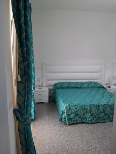a bedroom with two beds and a curtain at Le Castella B&B Restaurant in Le Castella