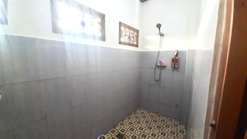 a bathroom with a shower with a tiled floor at Pesona 361 Alam Bungalows in Rarang