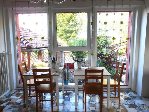 a dining room with a white table and chairs at Penzión Vilka Podhájčanka in Podhájska