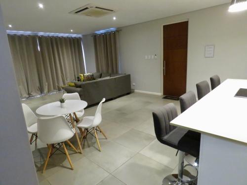 a conference room with a table and chairs and a couch at The Executive - Exclusive Self-Catering Apartments - Ezulwini in Ezulwini