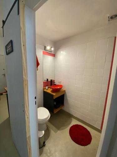 a bathroom with a toilet and a red sink at Tuc540 in Buenos Aires