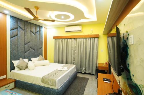 a bedroom with a bed with a ceiling fan at Goa Beach Resort ON Beach in Mandarmoni
