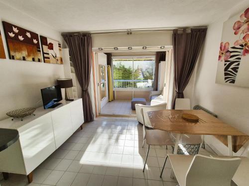 un salon avec une table et une salle à manger dans l'établissement 150 m plage, domaine privé avec piscine, à Six-Fours-les-Plages