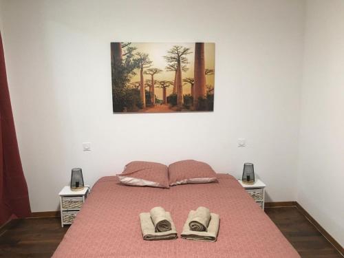 ein Schlafzimmer mit einem Bett mit zwei Hausschuhen darauf in der Unterkunft Belle Maison 8 pers Vatan centre in Vatan