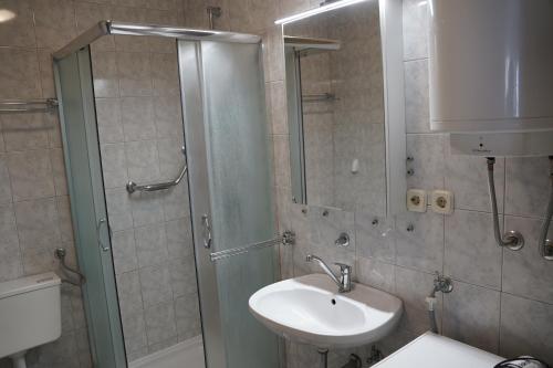 a bathroom with a sink and a shower and a sink at Rab From Above Studio Apartment in Rab