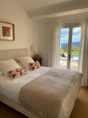 une chambre avec un lit et une porte coulissante en verre dans l'établissement Villa Maelvi, à Grimaud