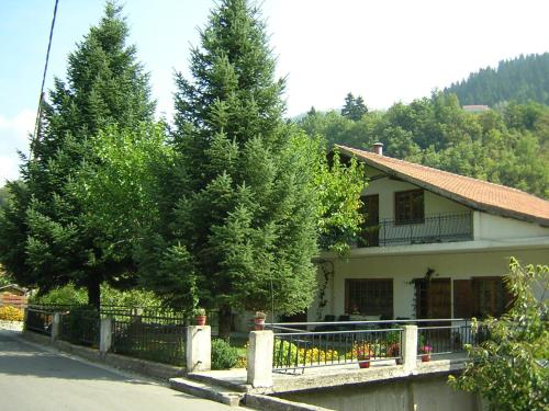 a house with trees in front of a fence at Agrampeli in Méga Khoríon