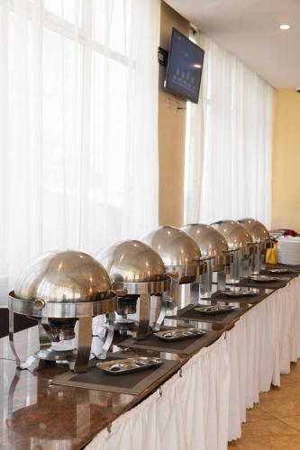 a row of silver domes lined up on a table at Dreamliner Hotel in Addis Ababa