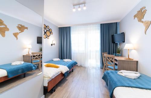 a hotel room with two beds and a desk at Resort Dankar in Dziwnów