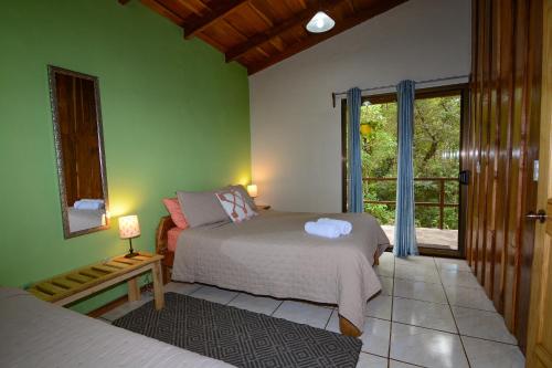 a bedroom with a bed and a window at Las Marias Monteverde - Mountain View Cottages & Gardens in Monteverde Costa Rica