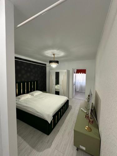 a bedroom with a large bed and a green table at Slatina Armoniei central Luxury Studio Oferim transport de la aeroport și retur contra cost in Slatina
