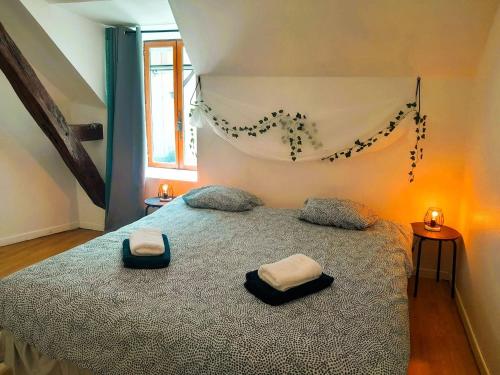 une chambre avec un lit avec deux oreillers dessus dans l'établissement Maison coquette 2 chambres jardin, à Reuilly