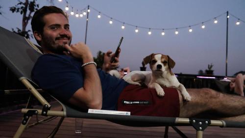 a man sitting in a chair with a dog on his lap at Funny Riverside Backpackers in Luang Prabang