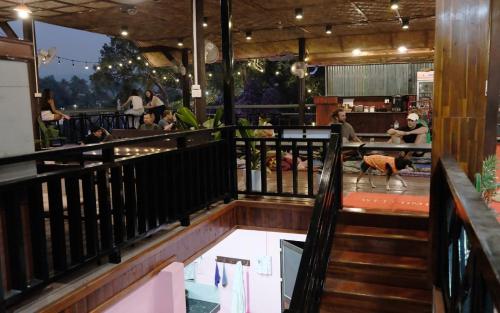 a restaurant with a dog standing on the balcony at Funny Riverside Backpackers in Luang Prabang