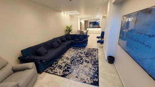a living room with a blue couch and a rug at Skyline Premium Properties in Alexandria