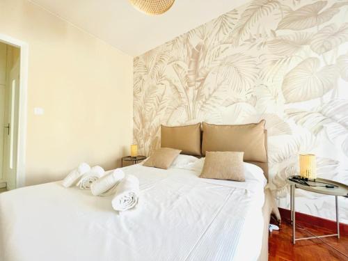 a bedroom with a white bed with towels on it at Sally's - Nel cuore di Sanremo in Sanremo