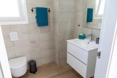a bathroom with a toilet and a sink at Beach Villa Playa Flamenca in Orihuela Costa