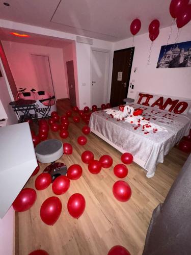 a room with red balloons on the floor and a bed at Lacasadelrelax in Monreale