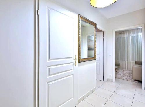 - une porte blanche dans la salle de bains pourvue d'un miroir dans l'établissement L'appartement Thibaud, à Paris