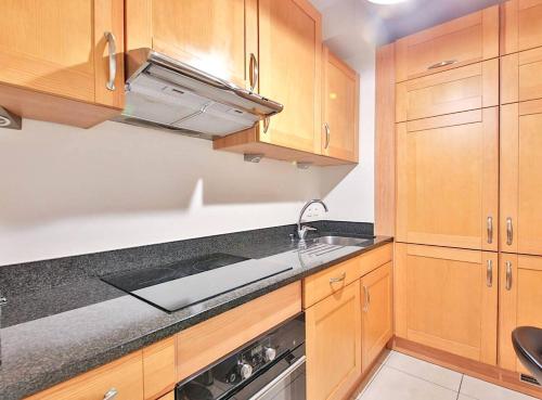 une cuisine avec des armoires en bois et un évier dans l'établissement L'appartement Thibaud, à Paris