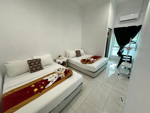 ein Wohnzimmer mit zwei Betten und einer Couch in der Unterkunft Temerloh Kenari Homestay in Temerloh