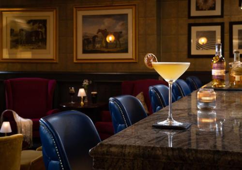 a bar with a table with a drink on it at Fitzpatrick Castle Hotel in Dalkey