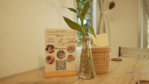 Ban Madua WanMY HOME Resort - Koh phangan vacation house rentals的书和桌子上的花瓶与植物