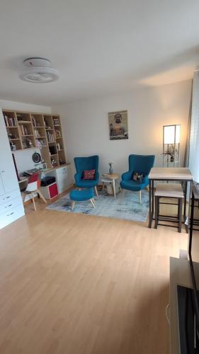 un salon avec des chaises bleues et une table dans l'établissement Charming T1 with balcony in Hyères, à Hyères