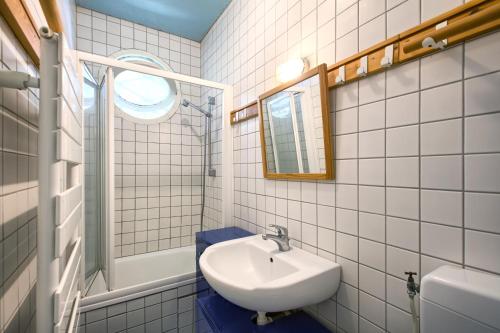 un bagno bianco con lavandino e specchio di Villa Surprise ad Arcachon