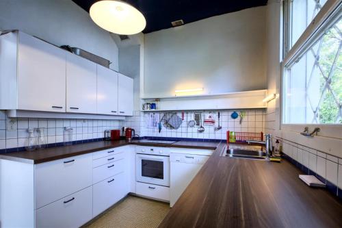 une cuisine avec des placards blancs et une grande fenêtre dans l'établissement Villa Surprise, à Arcachon