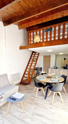 un salon avec une table et des chaises et un escalier dans l'établissement 