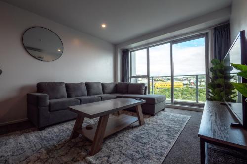 a living room with a couch and a table at Chic Urban Retreat in Grey Lynn in Auckland