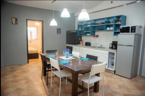 a kitchen with a dining room table and white appliances at La menuiserie- 2 chb-clim-wifi-parking in Châteauroux
