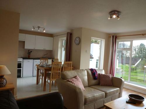 a living room with a couch and a table and a kitchen at 8 Manorcombe Bungalows in Callington